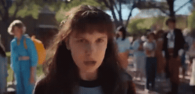 A Close Up Of A Girl With Long Hair Standing In Front Of A Crowd . GIF