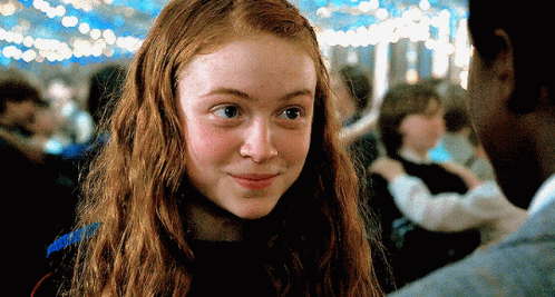 A Close Up Of A Girl With Red Hair Looking At A Man GIF
