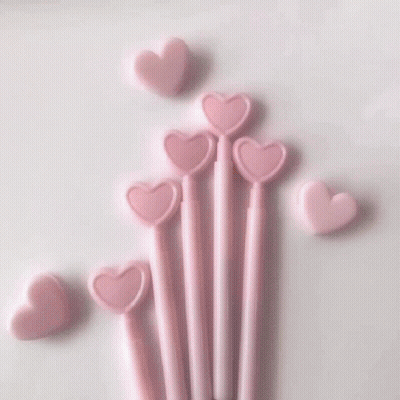 A Close Up Of A Glass Of Pink Liquid With Heart Shaped Ice Cubes GIF