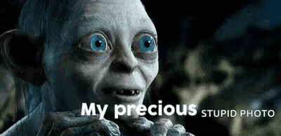 A Close Up Of A Gollum With Blue Eyes And The Words `` My Precious Stupid Photo '' Above Him . GIF