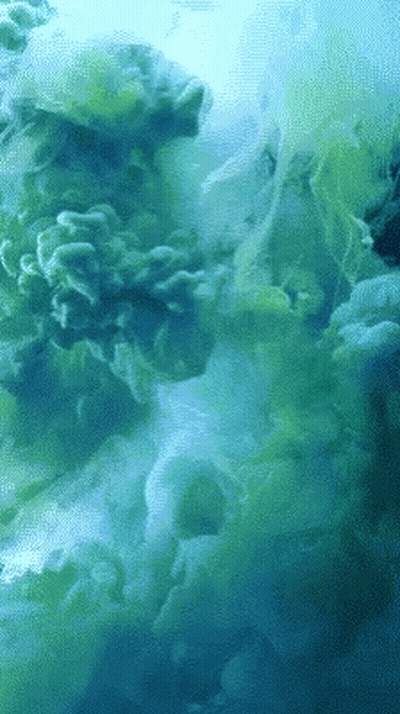 A Close Up Of A Green And Blue Smoke Coming Out Of The Water GIF