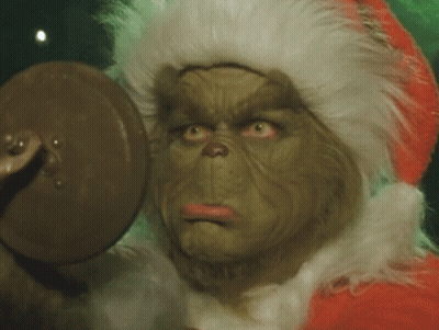 A Close Up Of A Grinch 'S Face With A Santa Hat On GIF