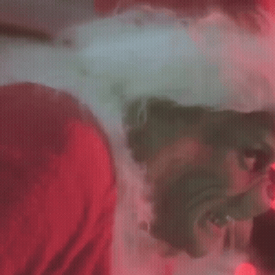 A Close Up Of A Grinch 'S Face With Glowing Red Eyes GIF