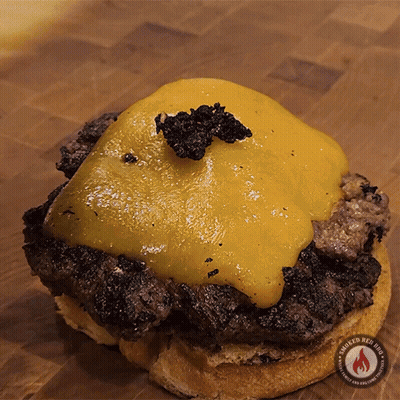 A Close Up Of A Hamburger On A Bun With Smoked Red Hot Written On The Bottom GIF
