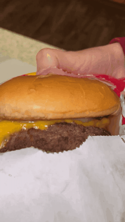 A Close Up Of A Hamburger With A Bun And Cheese GIF