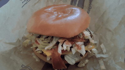 A Close Up Of A Hamburger With Lettuce And Bacon On It GIF