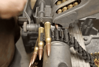 A Close Up Of A Machine With Bullets Coming Out Of It And A Sign That Says Good Grain GIF