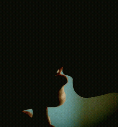 A Close Up Of A Man And Woman Kissing Each Other In The Dark . GIF