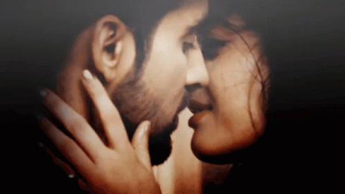 A Close Up Of A Man And Woman Kissing Each Other . GIF
