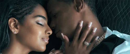 A Close Up Of A Man And Woman Kissing With The Woman 'S Hand On The Man 'S Neck GIF