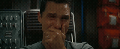 A Close Up Of A Man Covering His Mouth With His Hand . GIF