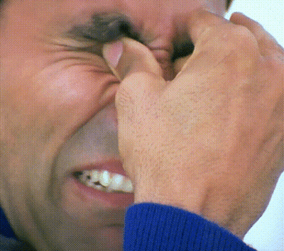 A Close Up Of A Man Covering His Nose With His Hands GIF