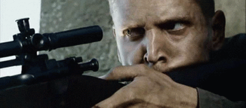 A Close Up Of A Man Holding A Rifle With A Scope On It GIF