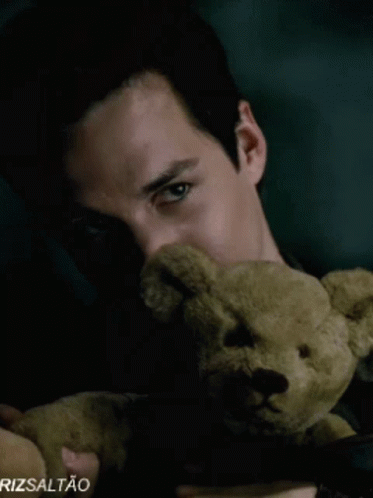 A Close Up Of A Man Holding A Teddy Bear With Rizsaltao Written On The Bottom Right GIF