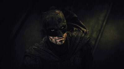 A Close Up Of A Man In A Batman Costume In The Dark GIF