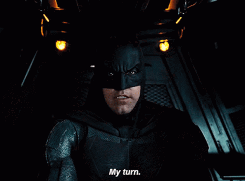 A Close Up Of A Man In A Batman Costume Saying My Turn GIF
