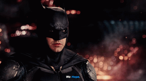 A Close Up Of A Man In A Batman Suit Saying We Hope GIF