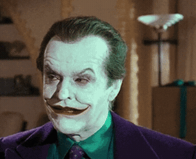 A Close Up Of A Man In A Purple Suit With A Green Shirt And Tie GIF