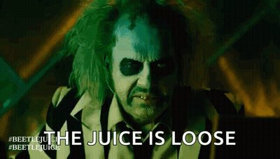 A Close Up Of A Man In A Striped Suit With The Words `` The Juice Is Loose '' Written On His Face . GIF