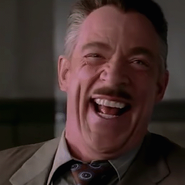 A Close Up Of A Man In A Suit And Tie Laughing . GIF