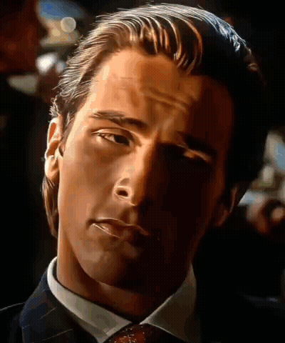 A Close Up Of A Man In A Suit And Tie Looking At The Camera GIF