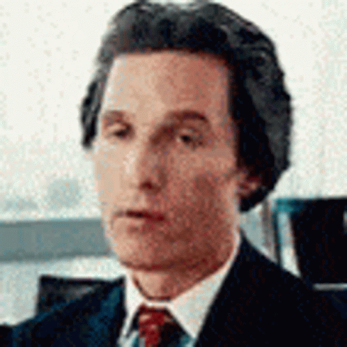 A Close Up Of A Man In A Suit And Tie Looking At The Camera . GIF