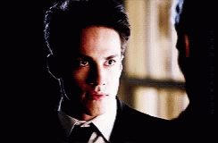 A Close Up Of A Man In A Suit And Tie Looking At The Camera GIF