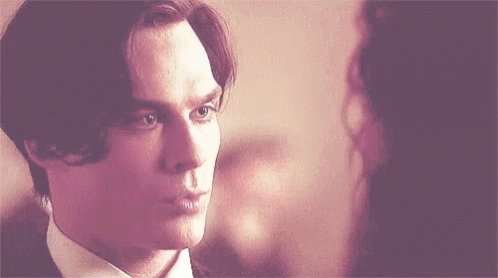 A Close Up Of A Man In A Suit Looking At A Woman . GIF