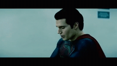 A Close Up Of A Man In A Superman Costume Looking Down . GIF