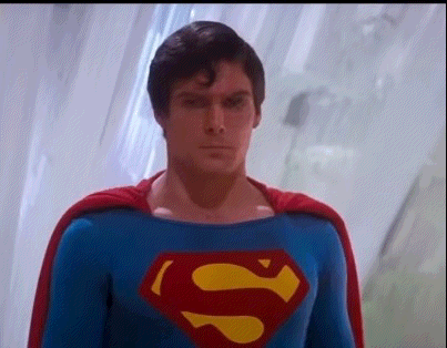 A Close Up Of A Man In A Superman Costume With A Cape . GIF