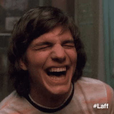 A Close Up Of A Man Laughing With His Eyes Closed And His Mouth Open . GIF
