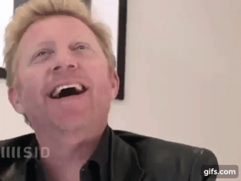 A Close Up Of A Man Laughing With His Mouth Open And His Eyes Closed . GIF