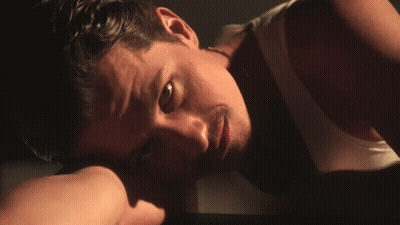 A Close Up Of A Man Laying Down With His Head On His Hand GIF