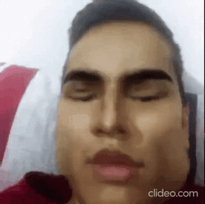 A Close Up Of A Man Laying In Bed With His Eyes Closed . GIF