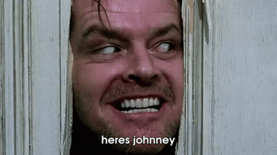 A Close Up Of A Man Looking Through A Door With The Words Heres Johnney Written Below Him GIF