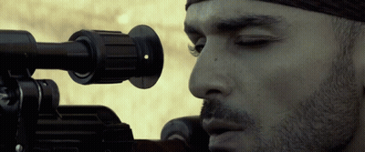 A Close Up Of A Man Looking Through A Sniper Rifle GIF