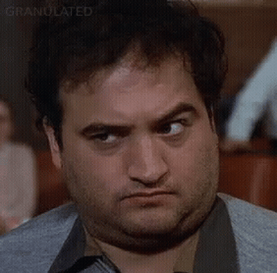 A Close Up Of A Man Making A Funny Face While Sitting At A Table . GIF