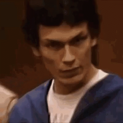 A Close Up Of A Man Making A Funny Face While Wearing A Blue Jacket And A White Shirt . GIF
