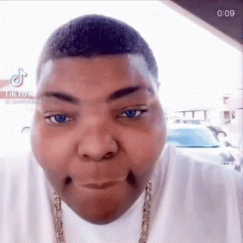 A Close Up Of A Man Making A Funny Face While Wearing A Chain Around His Neck . GIF