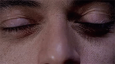 A Close Up Of A Man 'S Eyes With A Slight Smirk On His Face . GIF