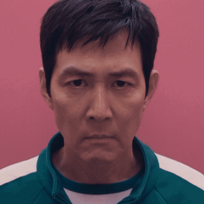 A Close Up Of A Man 'S Face Against A Pink Wall GIF