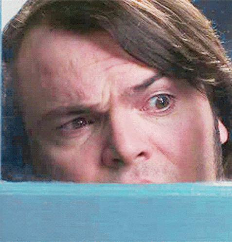 A Close Up Of A Man 'S Face Behind A Blue Wall GIF