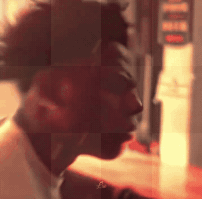 A Close Up Of A Man 'S Face In A Blurry Photo With A Red Background . GIF