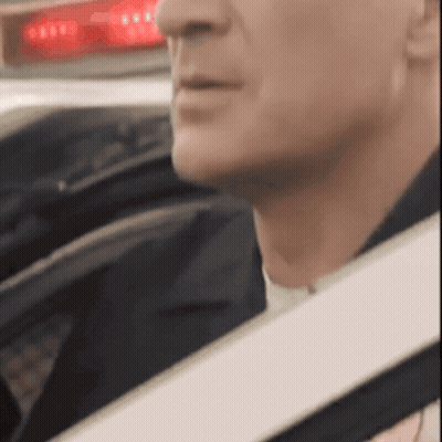 A Close Up Of A Man 'S Face In A Car With A Red Light Behind Him GIF