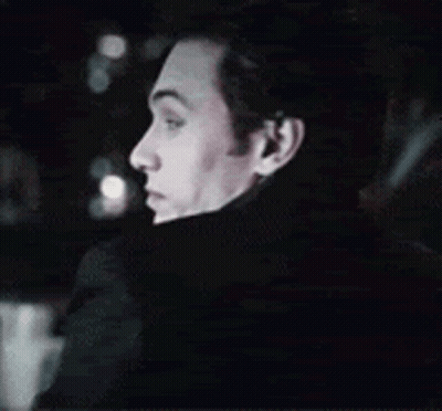 A Close Up Of A Man 'S Face In A Dark Room . GIF
