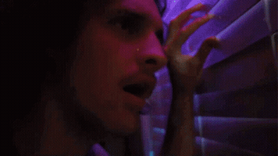 A Close Up Of A Man 'S Face In A Dark Room GIF