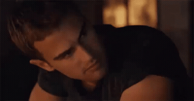A Close Up Of A Man 'S Face In A Dark Room Looking At The Camera . GIF
