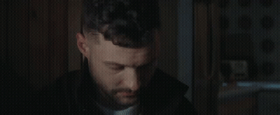 A Close Up Of A Man 'S Face In A Dark Room . GIF