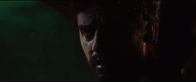 A Close Up Of A Man 'S Face In A Dark Room . GIF