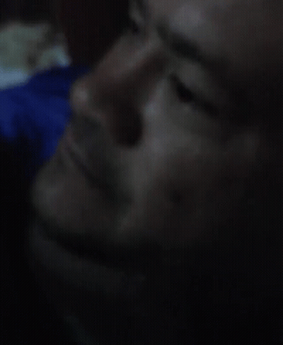 A Close Up Of A Man 'S Face In A Dark Room GIF